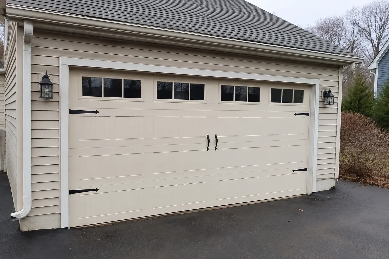 Cream carriage-house-style garage door with dark decorative hardware. — Carriage-House Garage Door Installation, Mapleton